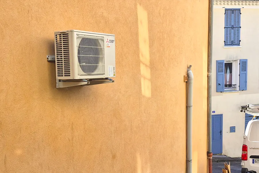 climatisation-mitsubishi-unite-exterieure-maison-pierre-la-garde Entretien de climatisation dans un appartement de la Côte varoise, unité intérieure installée dans un salon moderne avec balcon et immeubles en arrière-plan